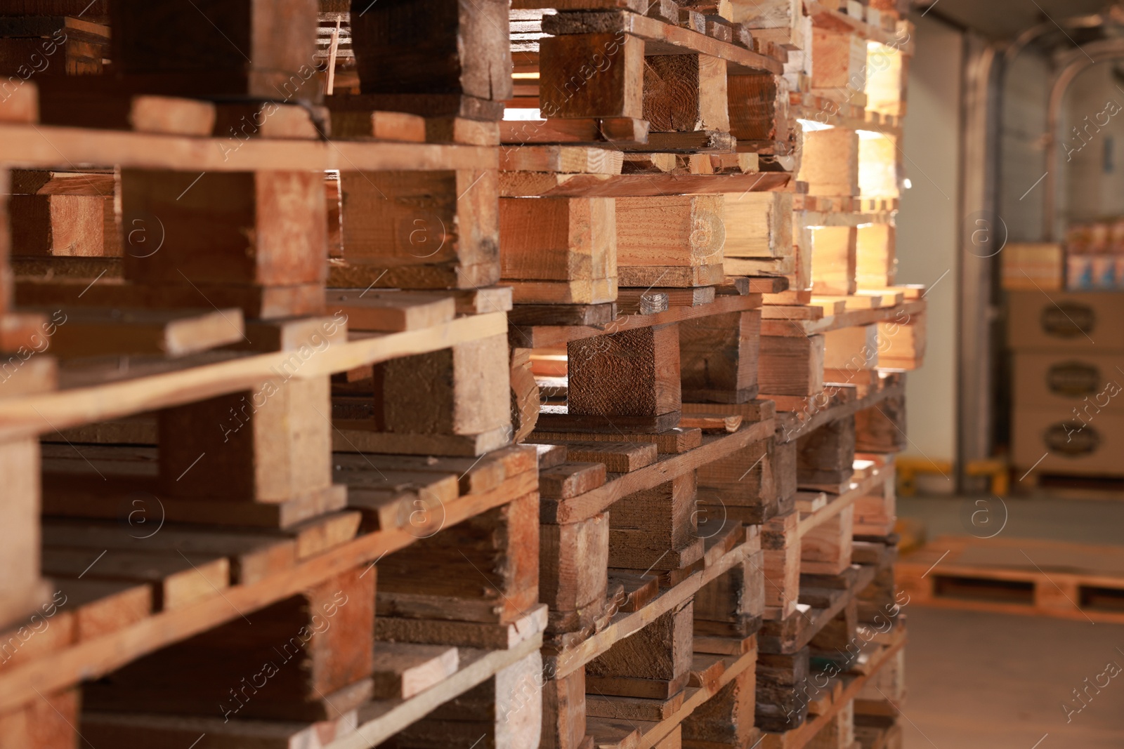 Image of Many empty wooden pallets stacked in warehouse