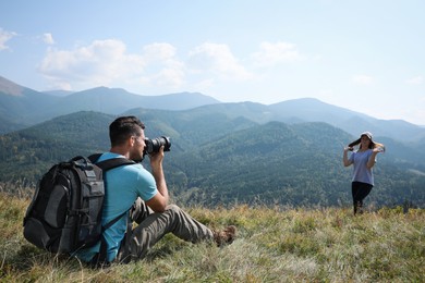 Photo of Professional photographer taking picture of woman in mountains