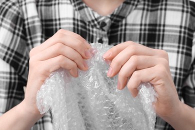 Photo of Woman popping bubble wrap, closeup. Stress relief