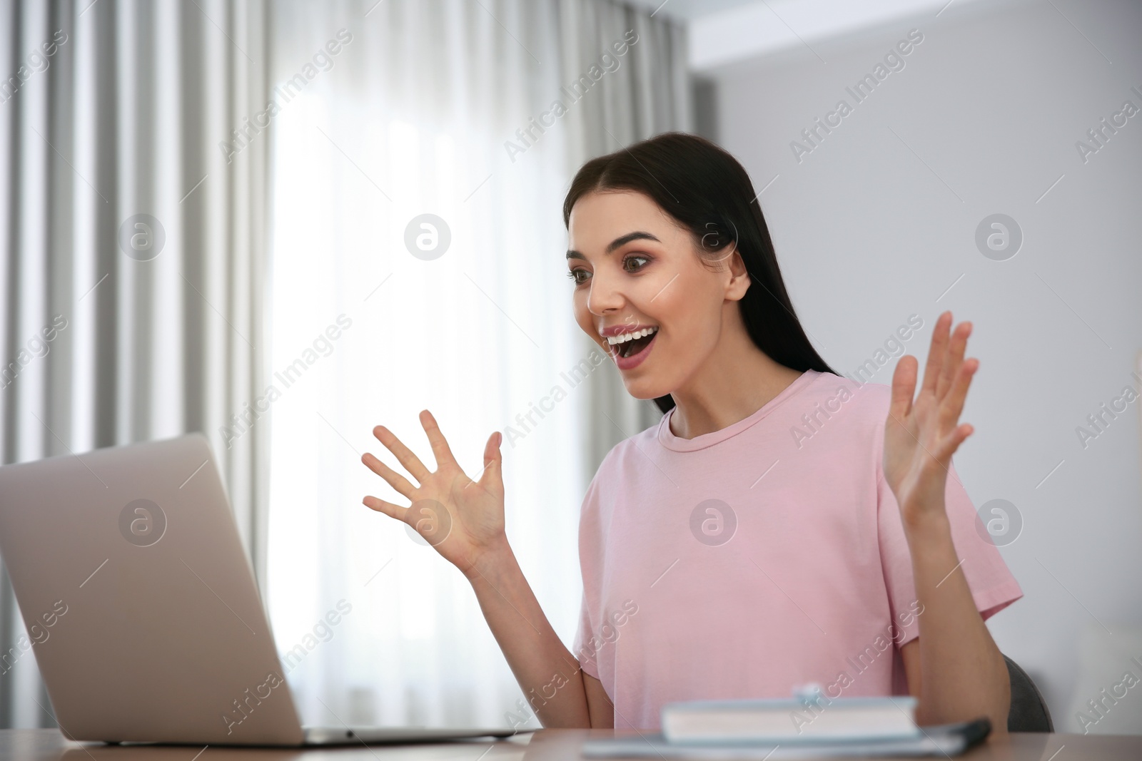 Photo of Emotional woman participating in online auction using laptop at home