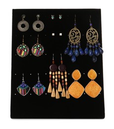 Photo of Display stand with different earrings on white background
