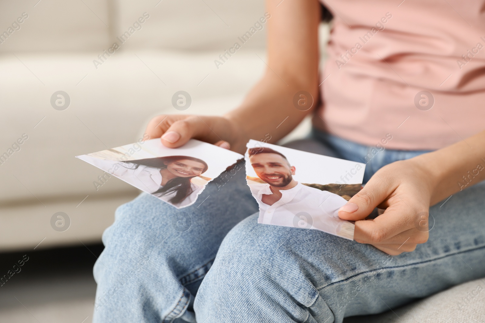 Photo of Woman holding torn photo indoors, closeup. Divorce concept