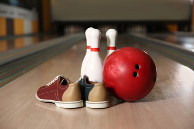 Photo of Shoes, pins and ball on bowling lane in club