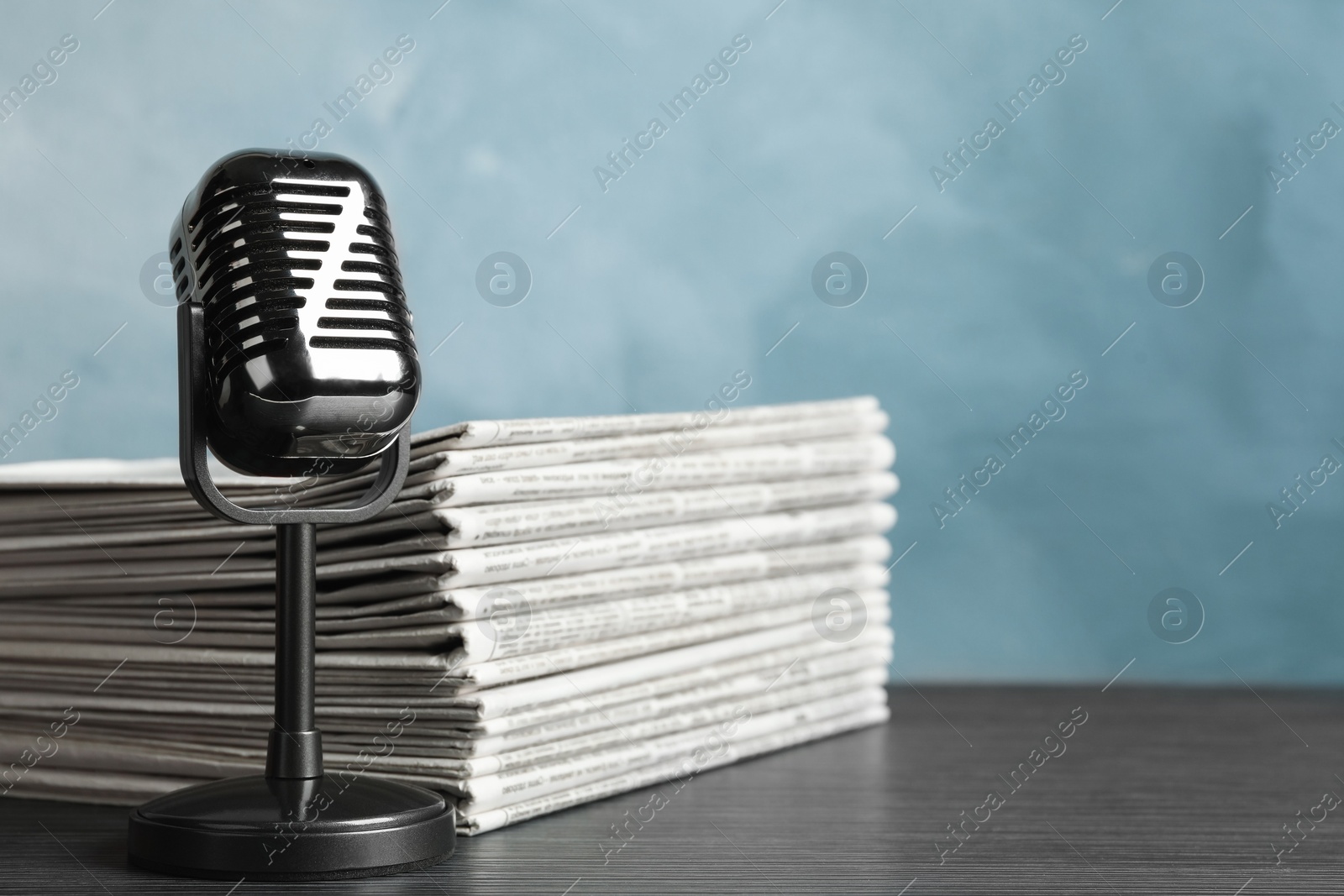 Photo of Newspapers and vintage microphone on table. Journalist's work