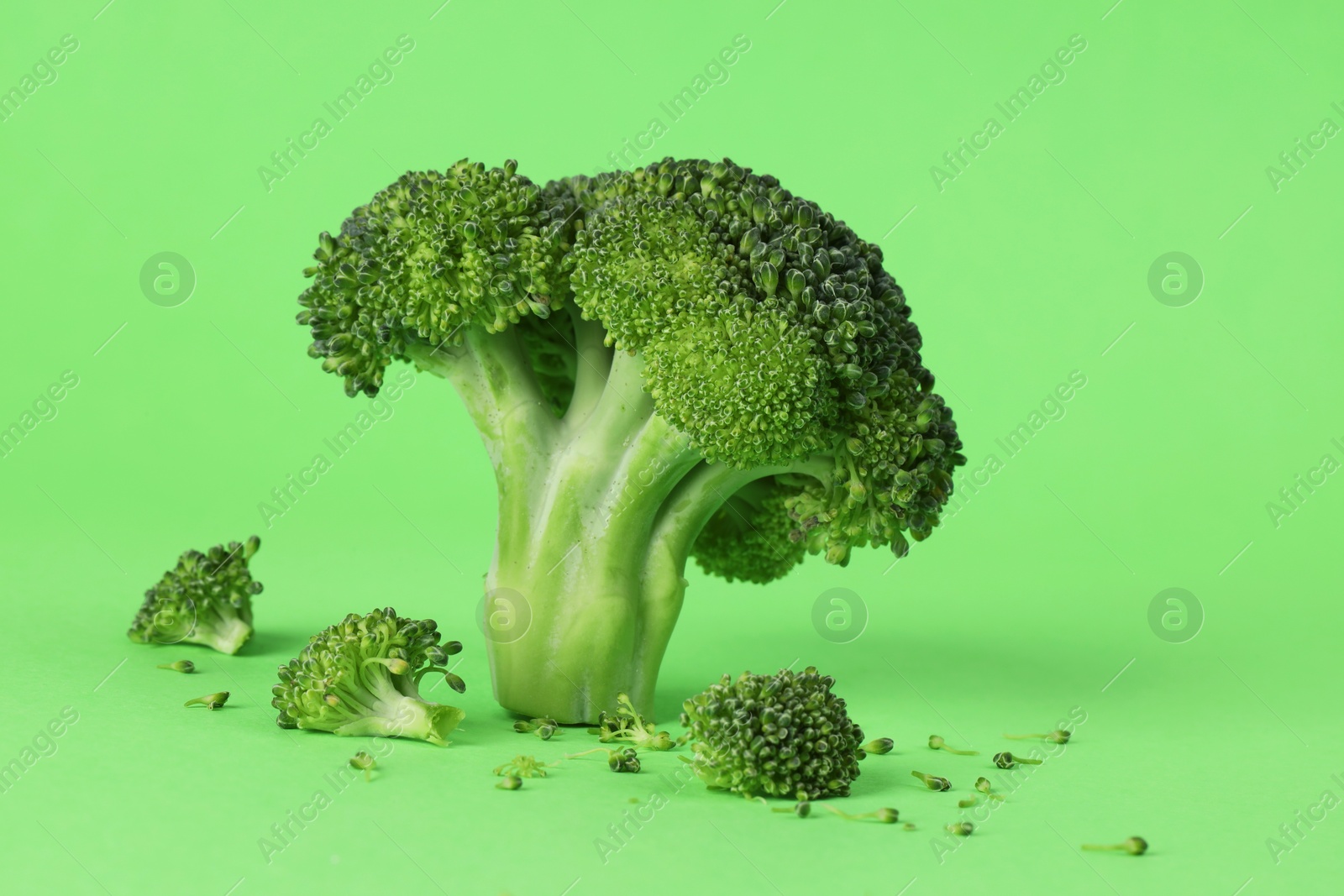 Photo of Fresh raw broccoli on light green background