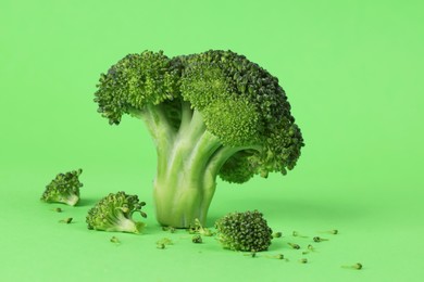 Fresh raw broccoli on light green background