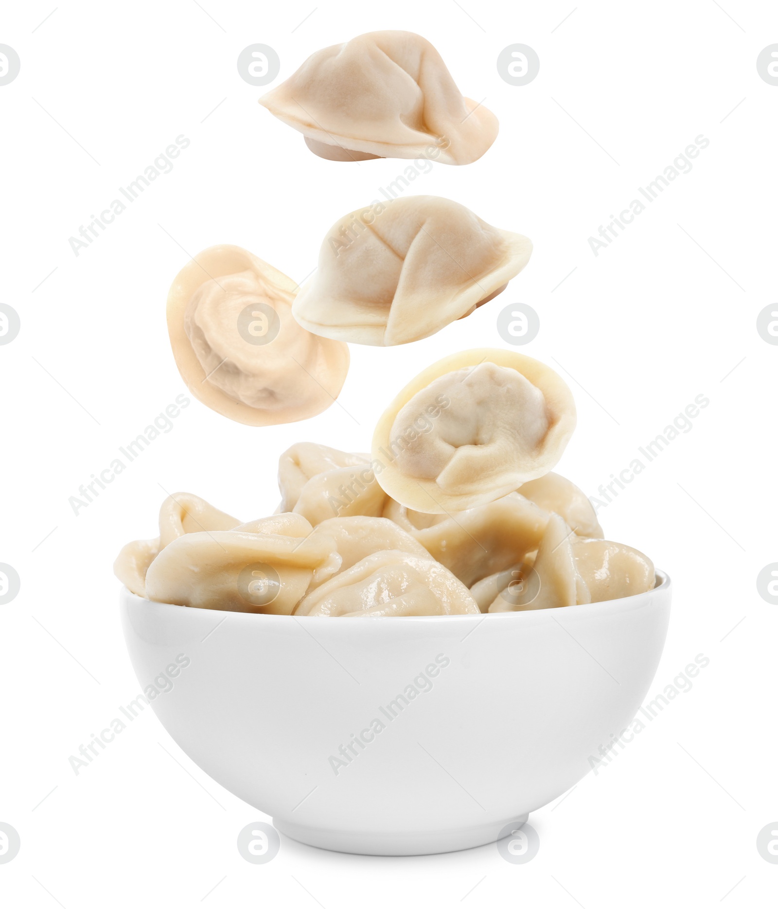 Image of Many tasty dumplings falling into bowl on white background