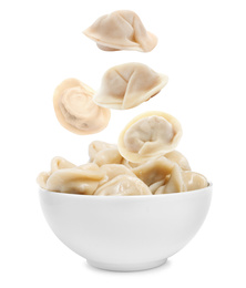 Many tasty dumplings falling into bowl on white background