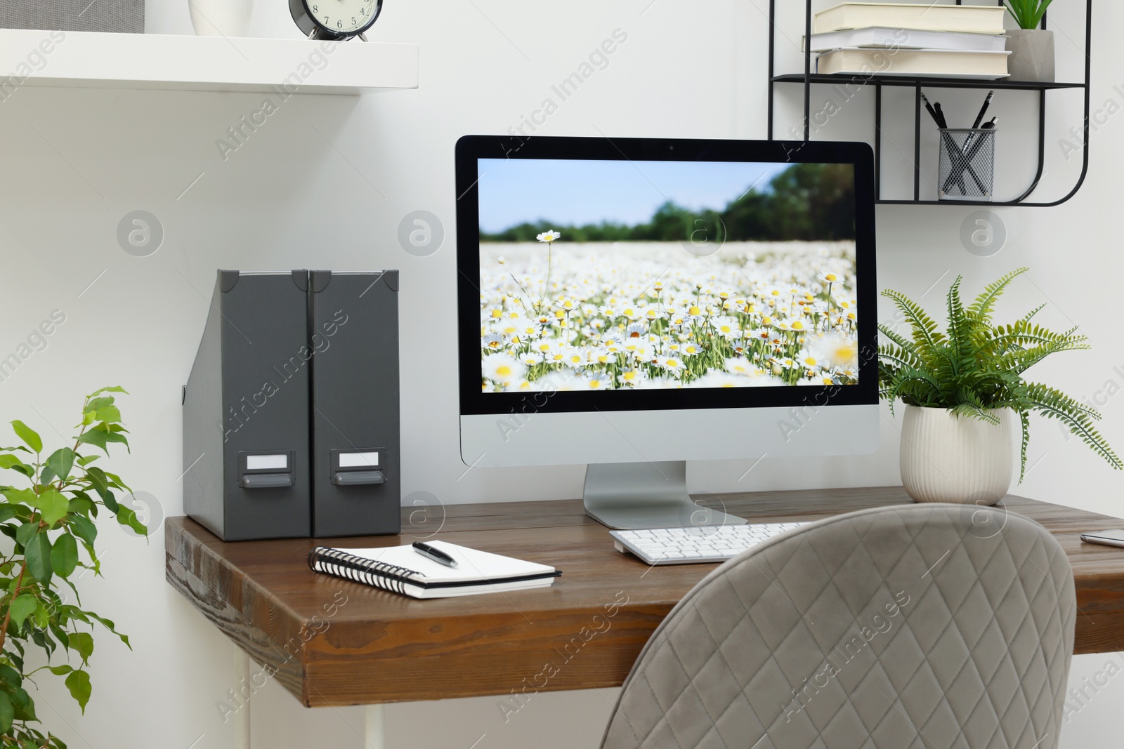 Photo of Cozy workspace with computer on wooden desk at home