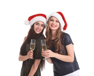 Photo of Beautiful young women in Santa hats with glasses of champagne on white background. Christmas celebration