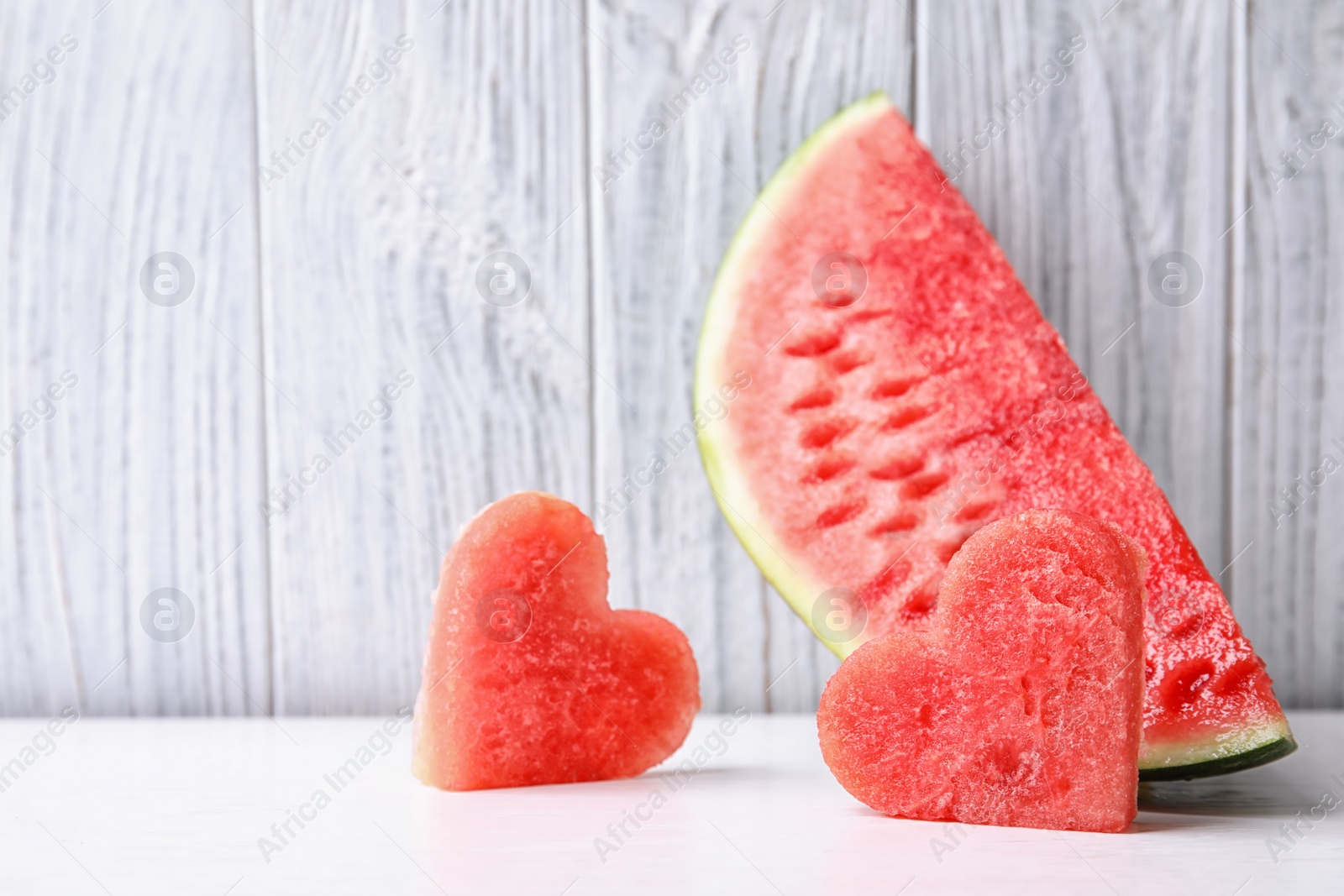 Photo of Juicy watermelon slices on table against light background