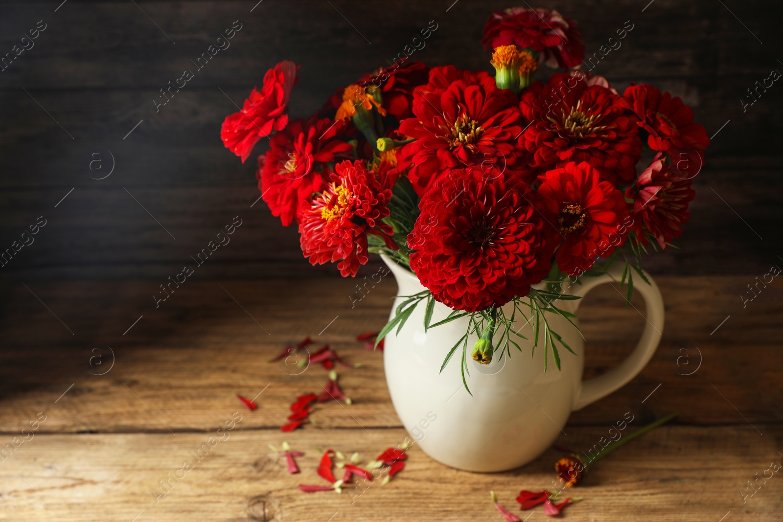 Photo of Bouquet of beautiful wild flowers on wooden table against black background. Space for text