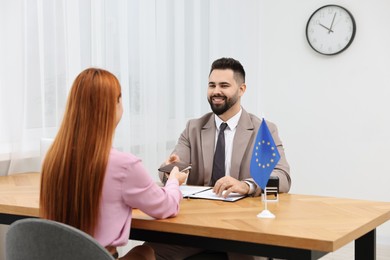 Immigration to European Union. Woman having interview with embassy worker in office