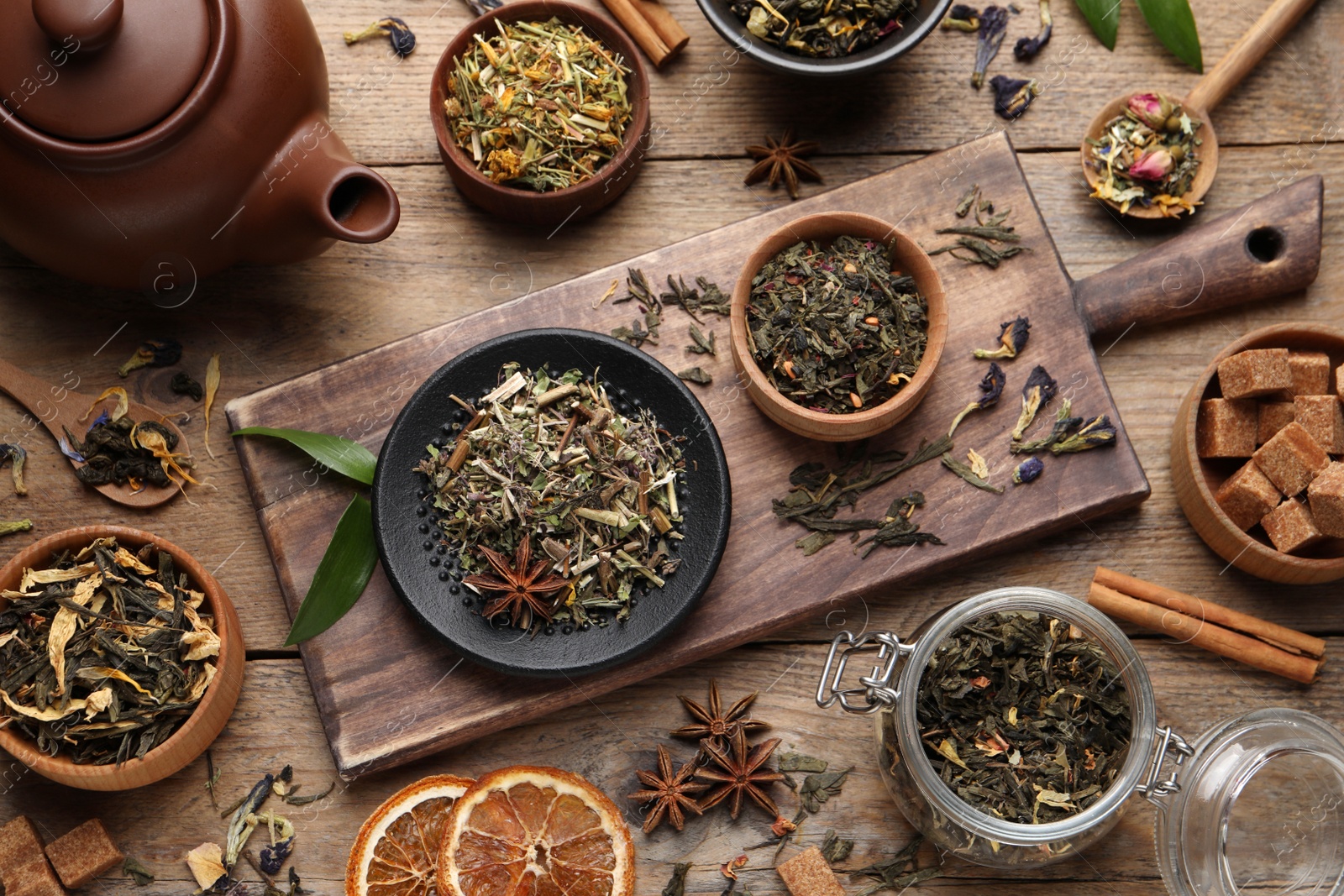 Photo of Flat lay composition with different dry teas on wooden table