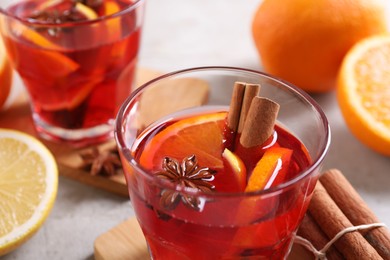 Photo of Glass with aromatic punch drink on table, closeup