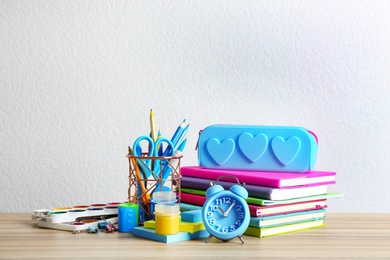 Different school stationery on wooden table against white background