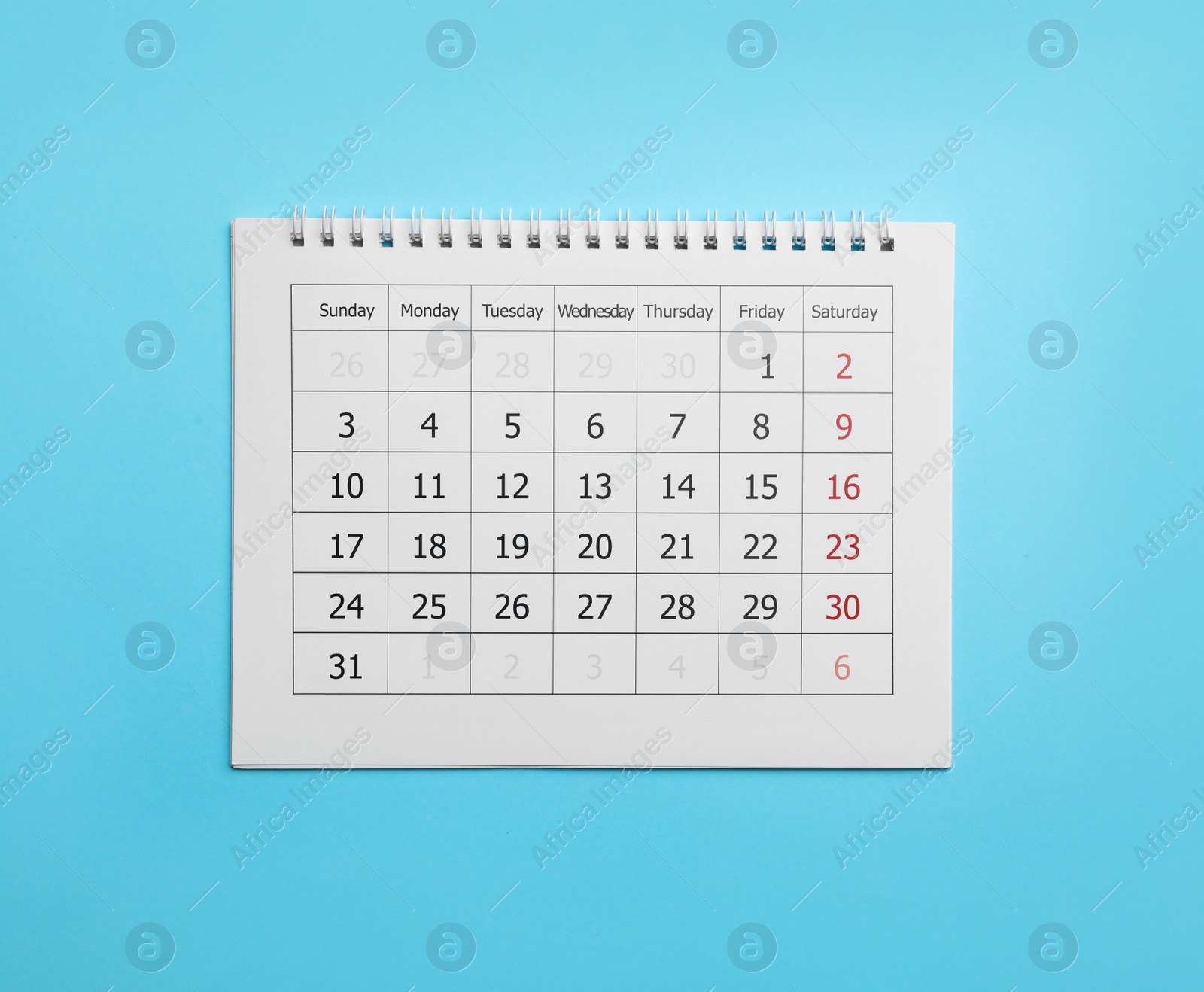 Photo of Paper calendar on light blue background, top view