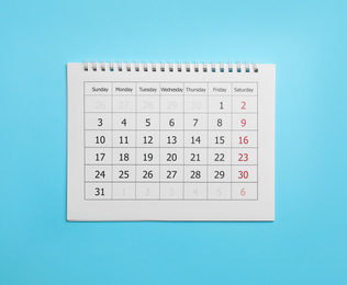 Paper calendar on light blue background, top view