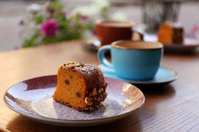 Photo of Plate with slice of carrot cake on wooden table