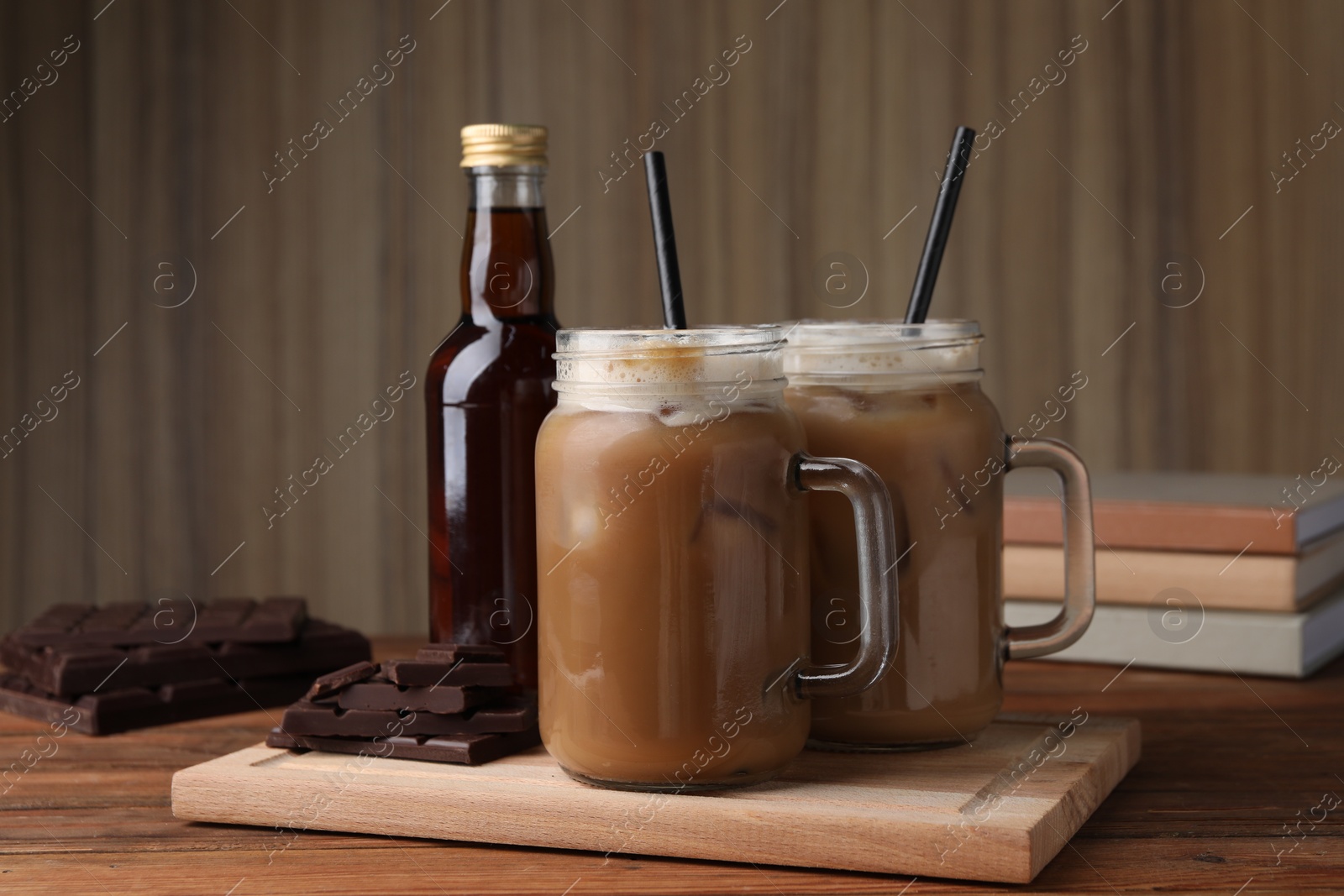 Photo of Delicious iced coffee with chocolate syrup on wooden table