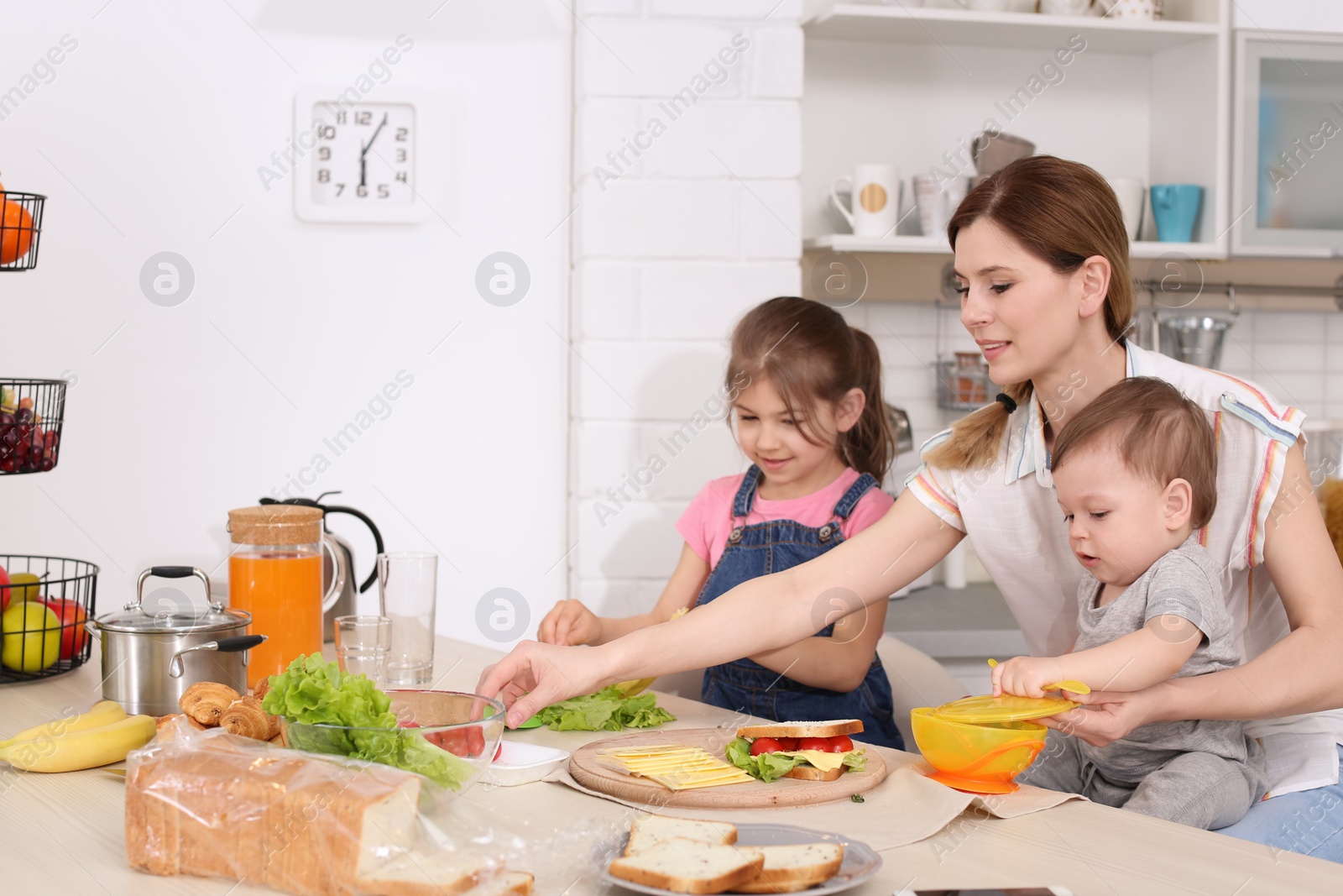 Photo of Housewife preparing dinner with her children on kitchen