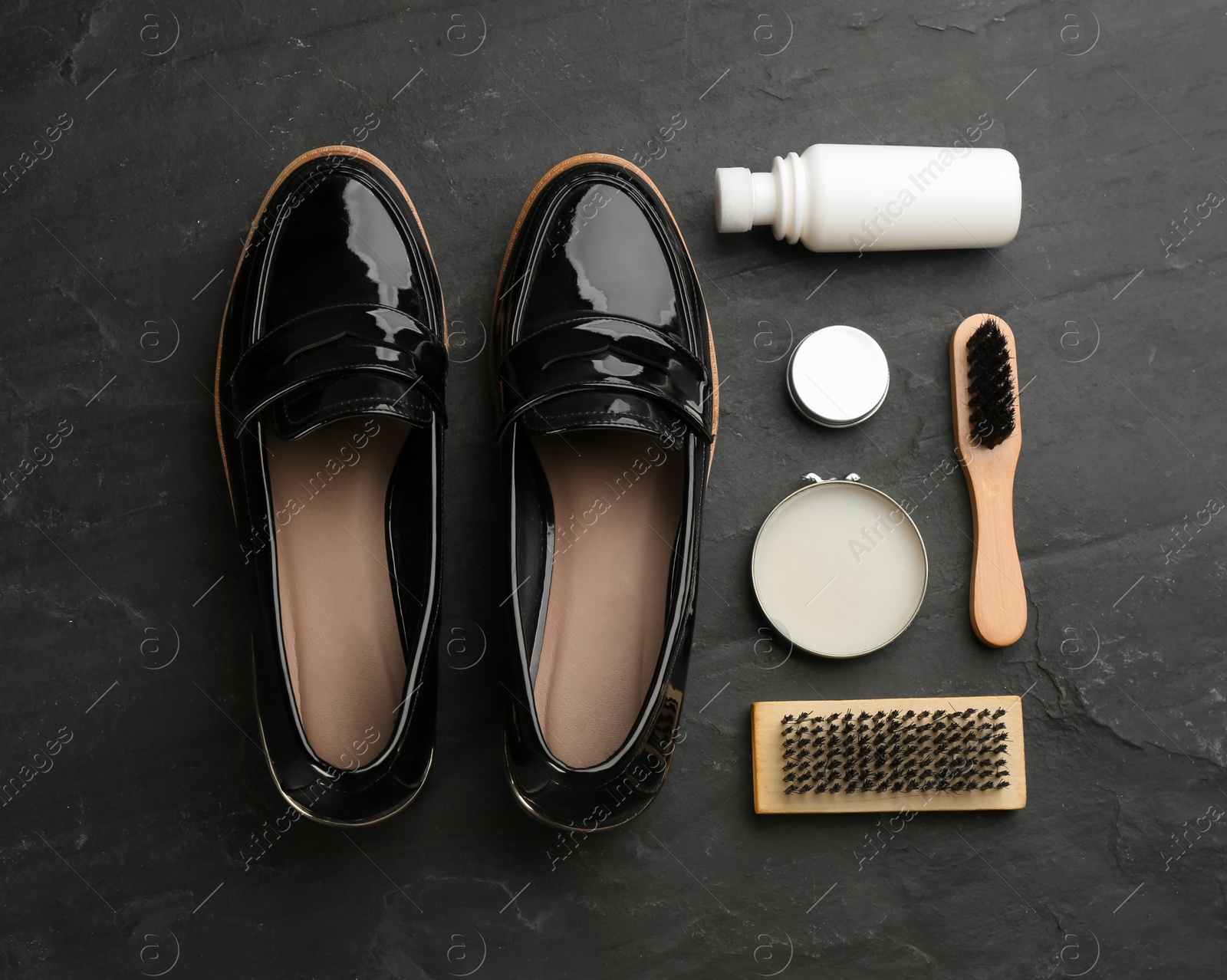 Photo of Flat lay composition with shoe care accessories and footwear on black background