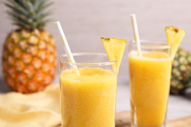 Photo of Tasty pineapple smoothie and fresh fruits on table, closeup