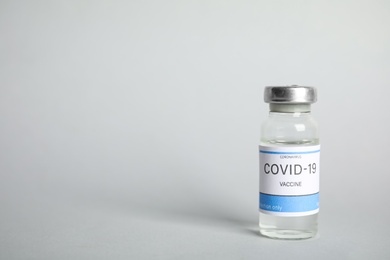 Photo of Vial with coronavirus vaccine on light background, space for text