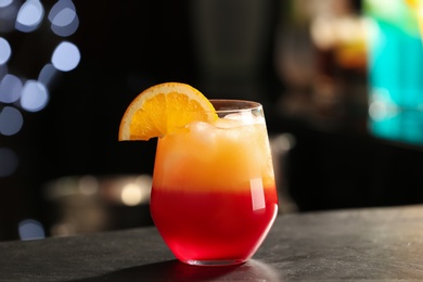 Photo of Delicious cocktail with orange on bar counter