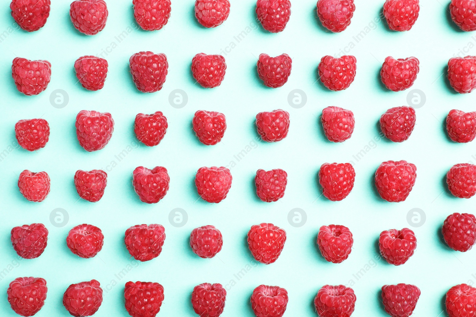 Photo of Flat lay composition with ripe aromatic raspberries on color background