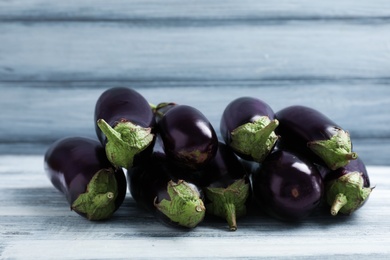 Photo of Tasty raw ripe eggplants on wooden table