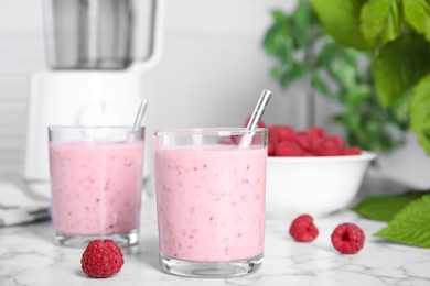 Tasty fresh raspberry smoothie on white marble table