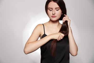Photo of Beautiful young woman with healthy strong hair posing in studio