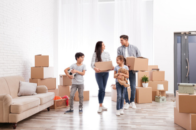 Happy family in room with cardboard boxes on moving day