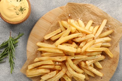 Photo of Delicious french fries served with sauce on grey table, flat lay