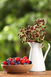 Different fresh berries on wooden table outdoors