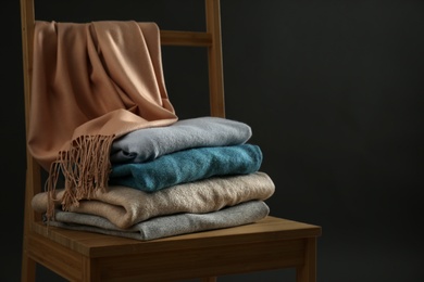 Stack of cashmere clothes on wooden chair