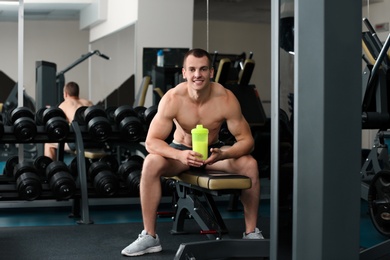 Photo of Athletic young man with protein shake in gym