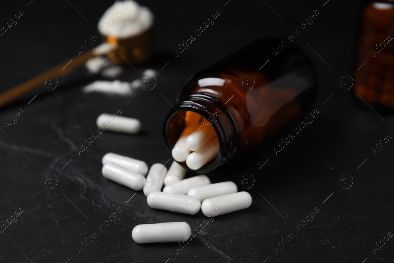 Photo of Jar with amino acid pills on black table