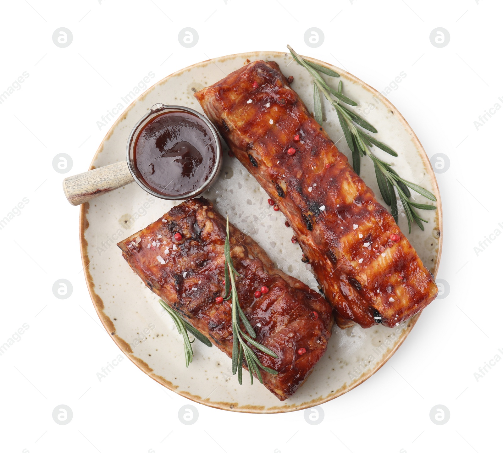 Photo of Tasty roasted pork ribs, sauce and rosemary isolated on white, top view