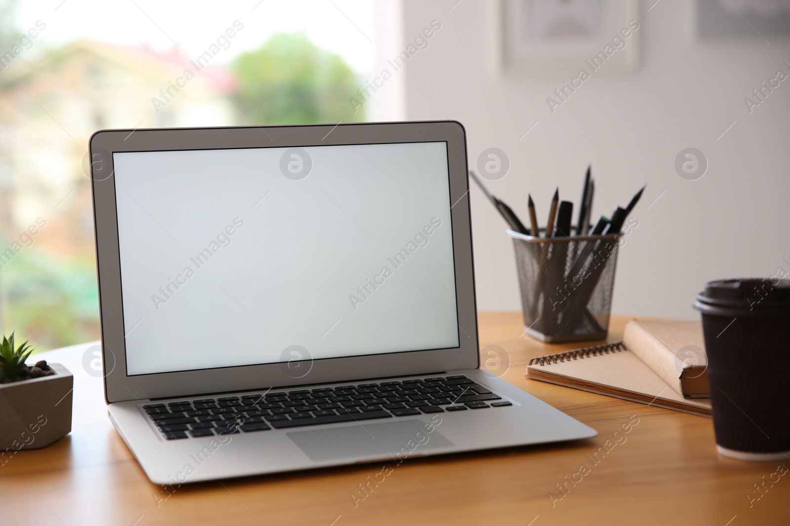 Photo of Modern laptop and cup of coffee on wooden table indoors. Space for design