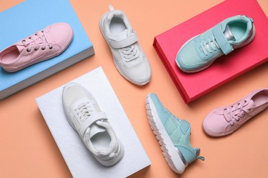 Flat lay composition with different stylish sports shoes on pale coral background