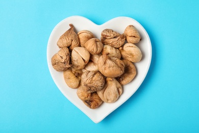 Photo of Plate with dried figs on color background, top view. Healthy fruit