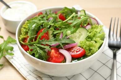 Photo of Delicious salad with arugula and vegetables on table, closeup