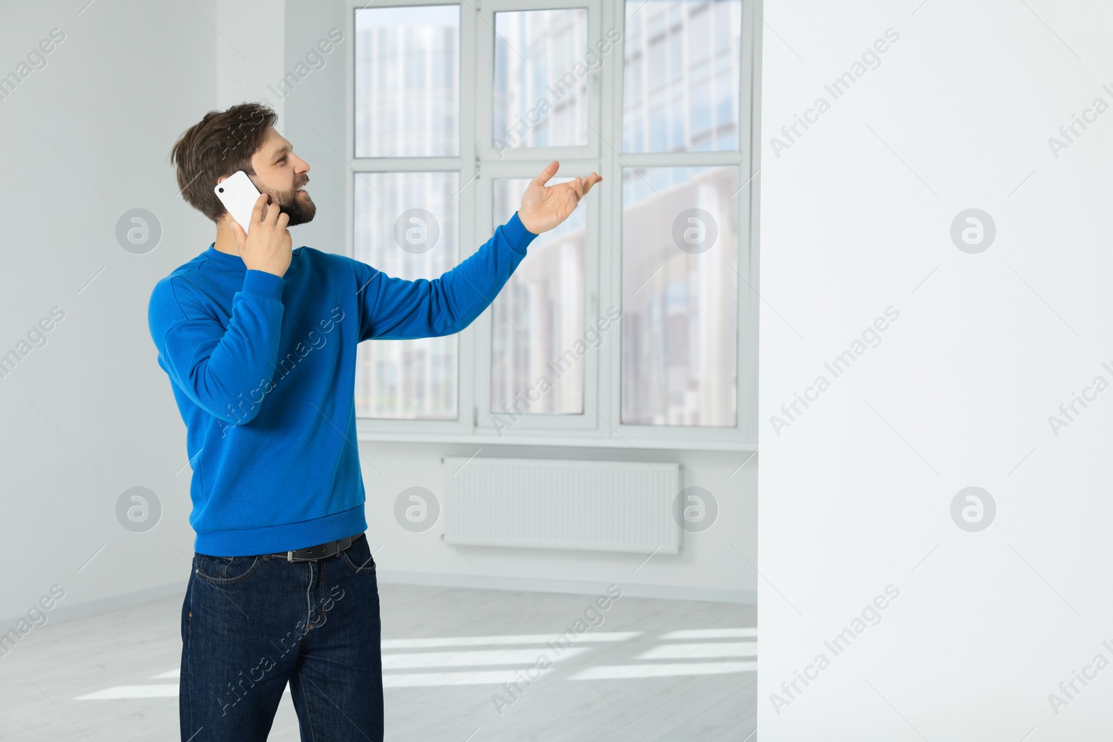 Photo of Man in casual clothes talking on phone indoors, space for text