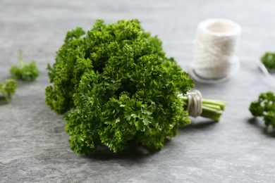 Photo of Bunch of fresh curly parsley on grey table