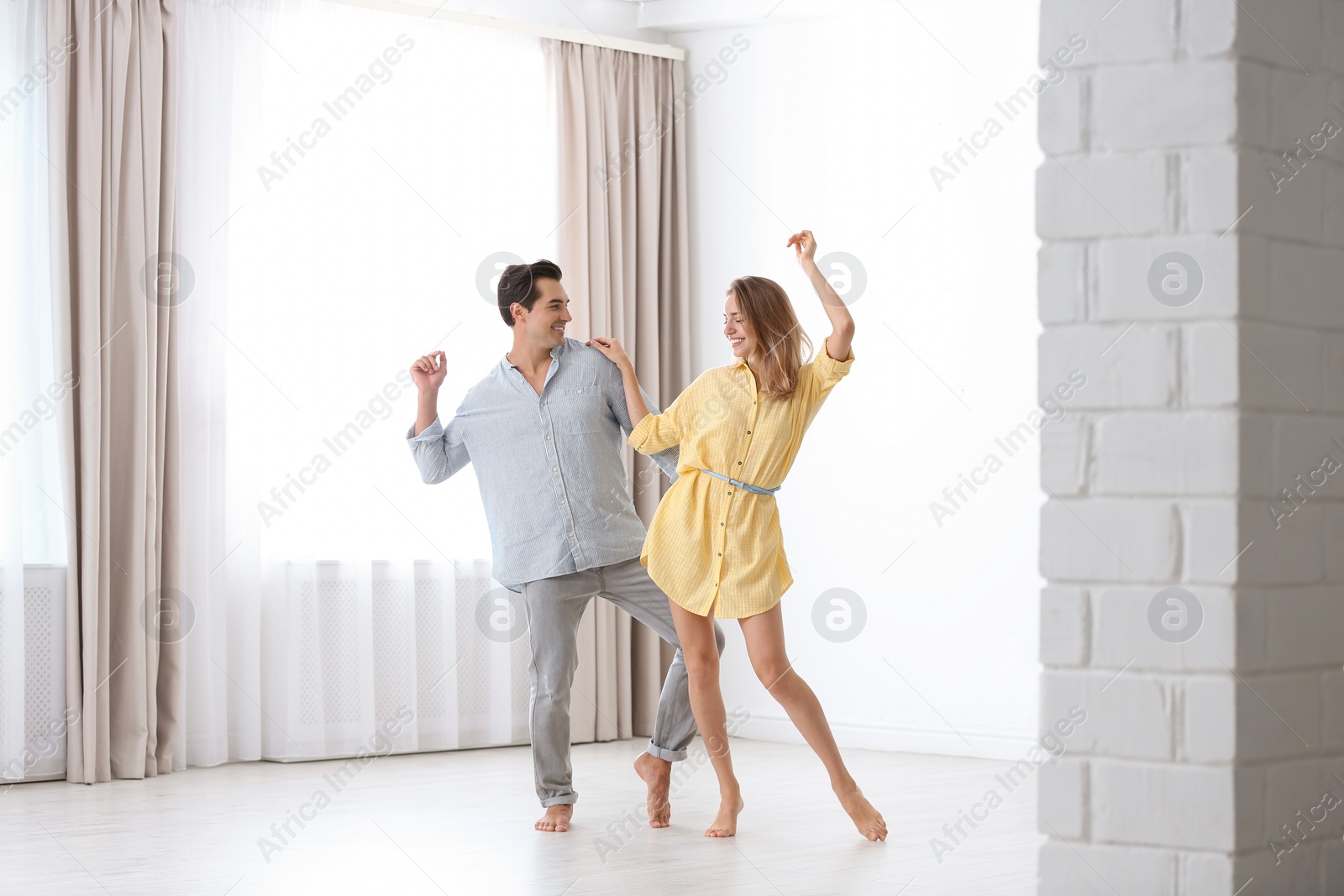 Photo of Beautiful young couple dancing in room at home