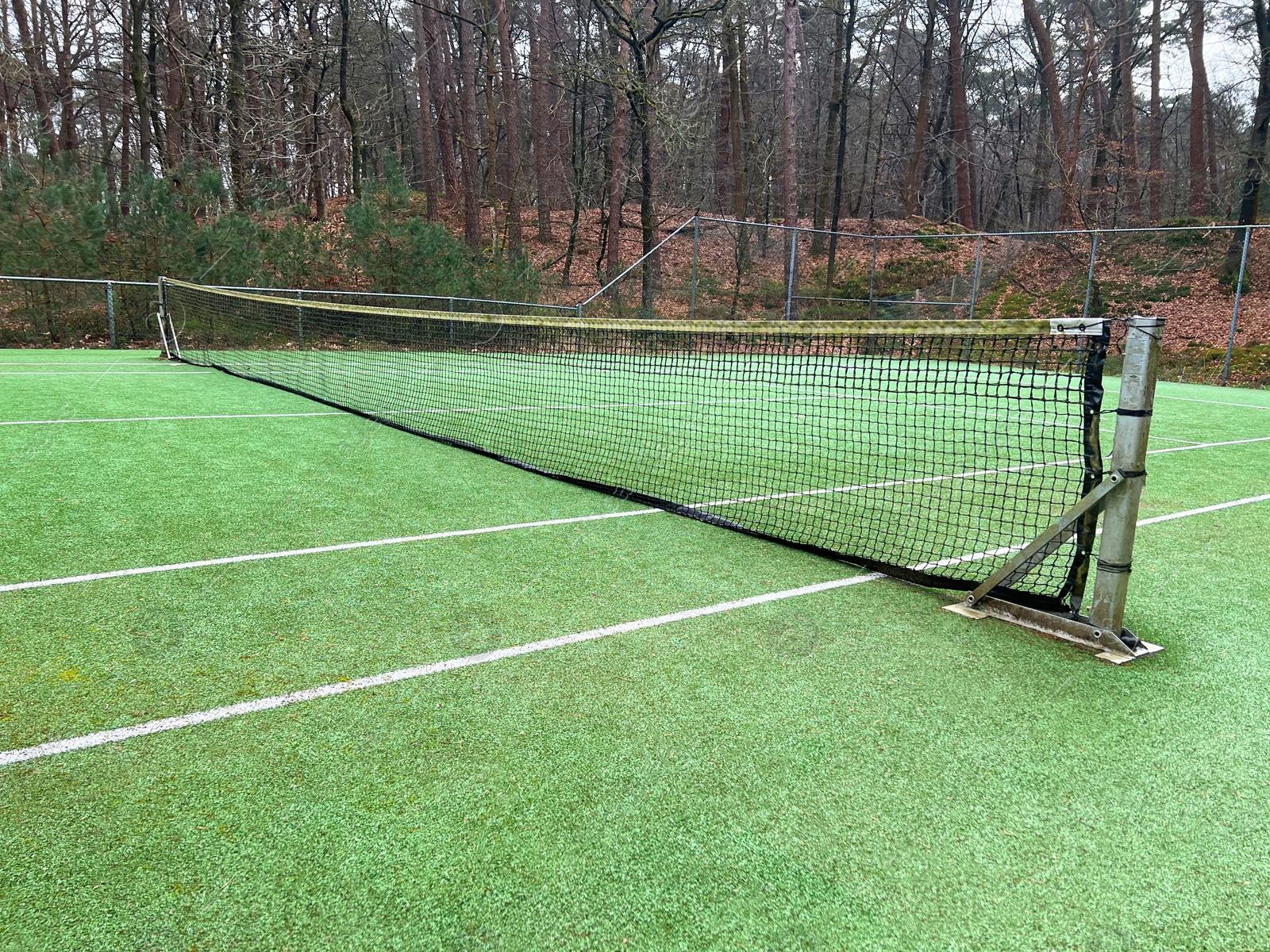 Photo of Tennis court with artificial grass and net outdoors