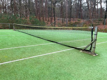 Tennis court with artificial grass and net outdoors