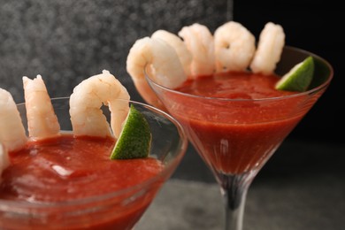 Tasty shrimp cocktail with sauce and lime in glasses on table, closeup